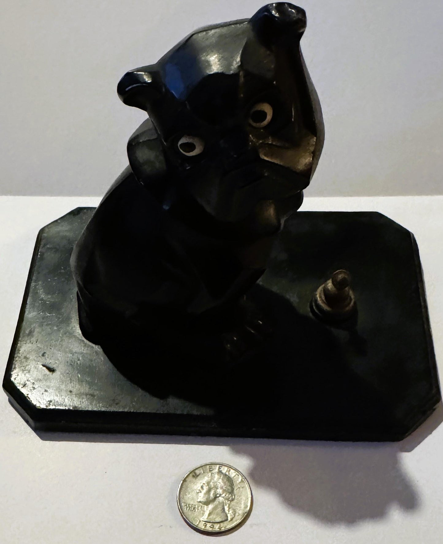 Black cast metal Art Deco bulldog inkwell on rectangular base with quarter coin for scale, shown from front angle against whi