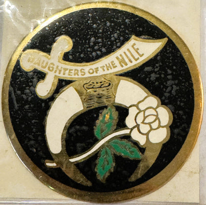 Circular vintage decal with gold border featuring white flower and green leaves on black background, text reads "Daughters of