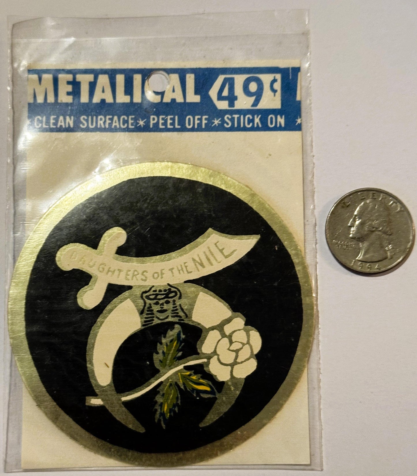 Metallic stick-on decal featuring Daughters of the Nile logo with scimitar and flower on black background, priced 49¢, shown 