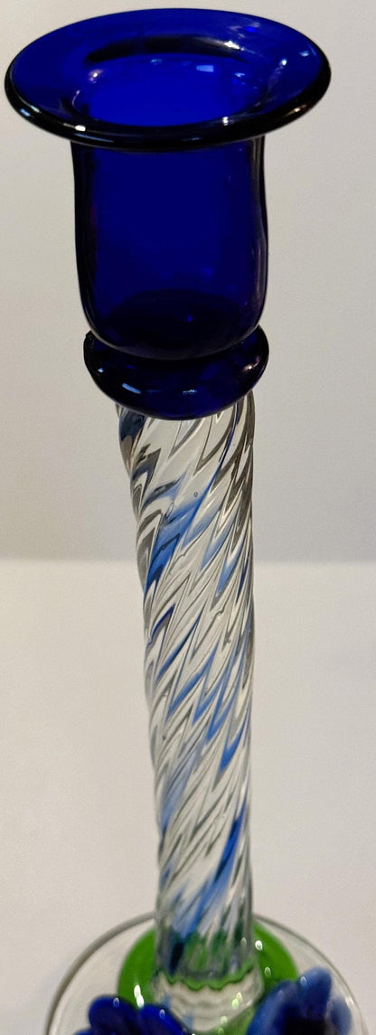Tall blue art glass candlestick with twisted clear and blue latticino stem, green and blue applied base, shown against white 