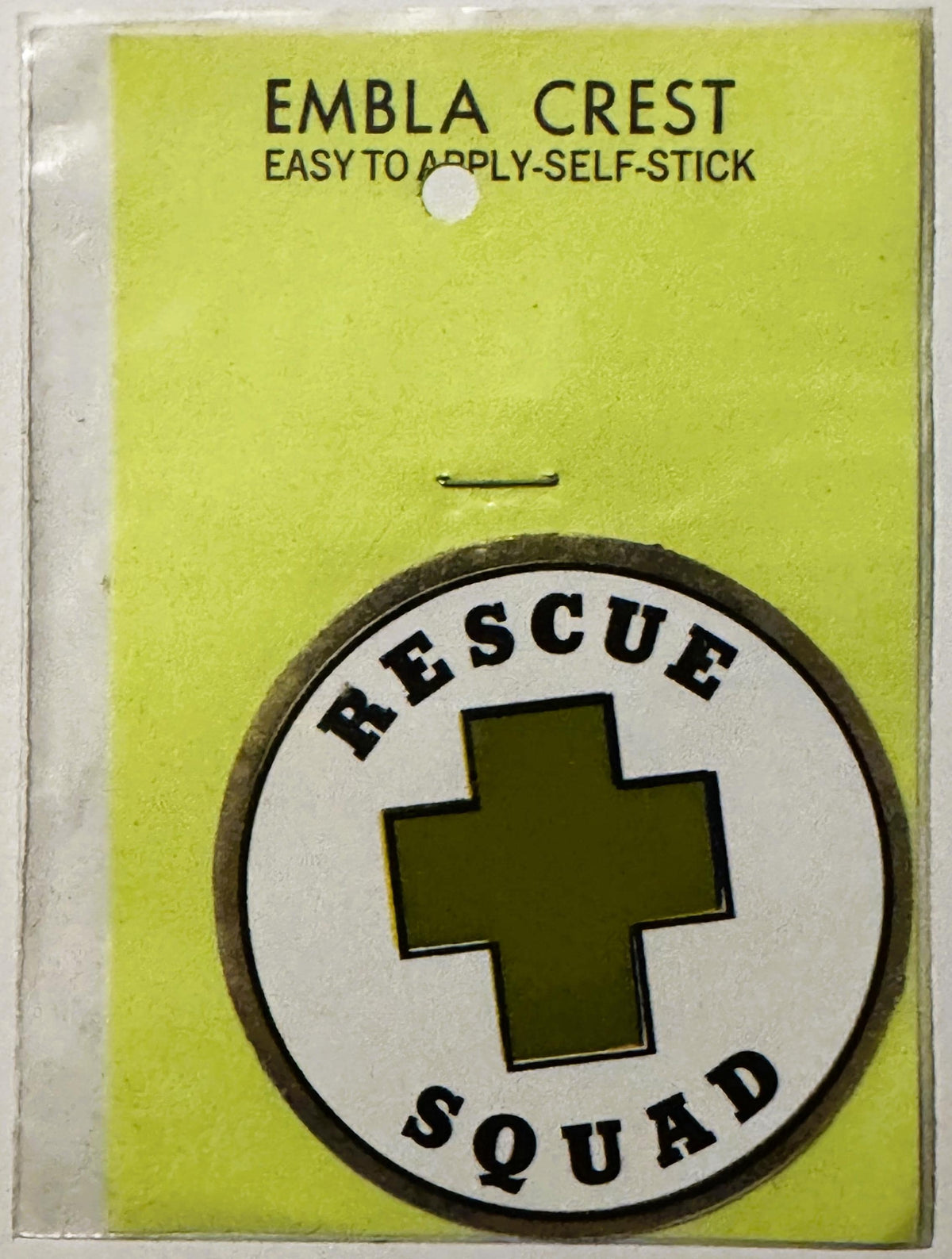 Unopened vintage Rescue Squad emblem crest decal on yellow-green backing with self-stick application instructions, featuring 
