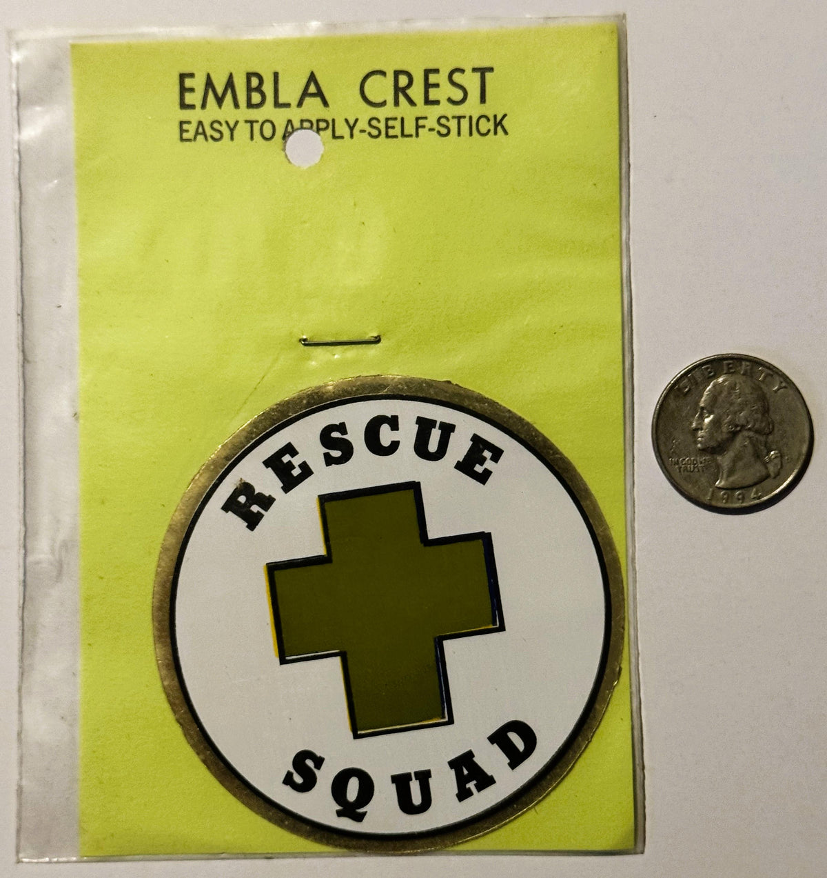 Vintage self-stick embla crest decal showing "Rescue Squad" text around olive cross on white circle, displayed on yellow back