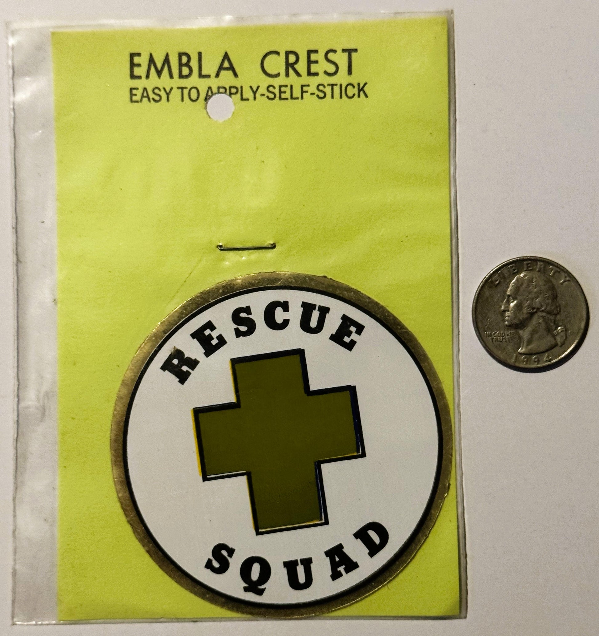 Vintage self-stick embla crest decal showing "Rescue Squad" text around olive cross on white circle, displayed on yellow back