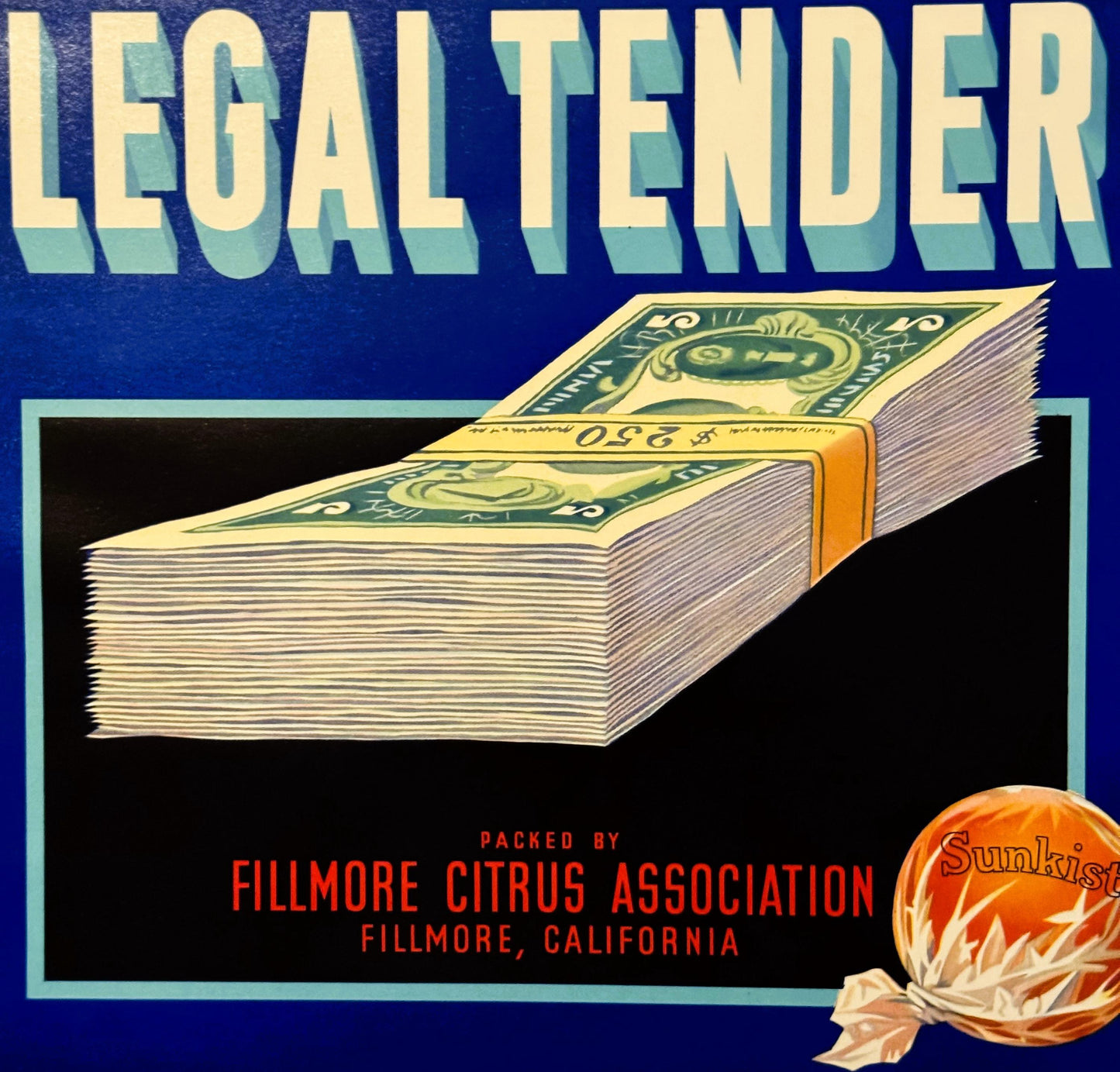 Vintage fruit crate label featuring "Legal Tender" in large cream text on blue background, with stack of dollar bills and ora