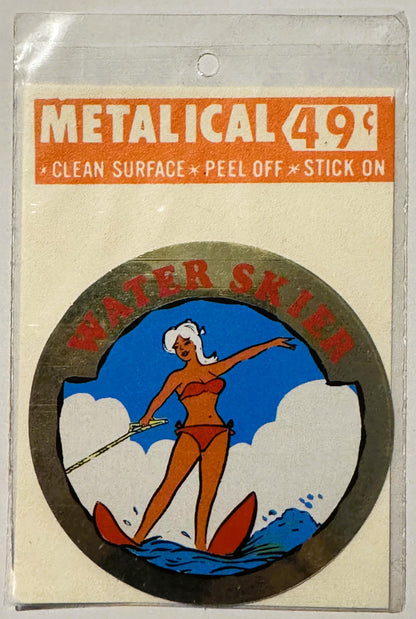 Unopened vintage metallic decal sticker in clear packaging showing illustrated woman water skier in red bikini against blue s