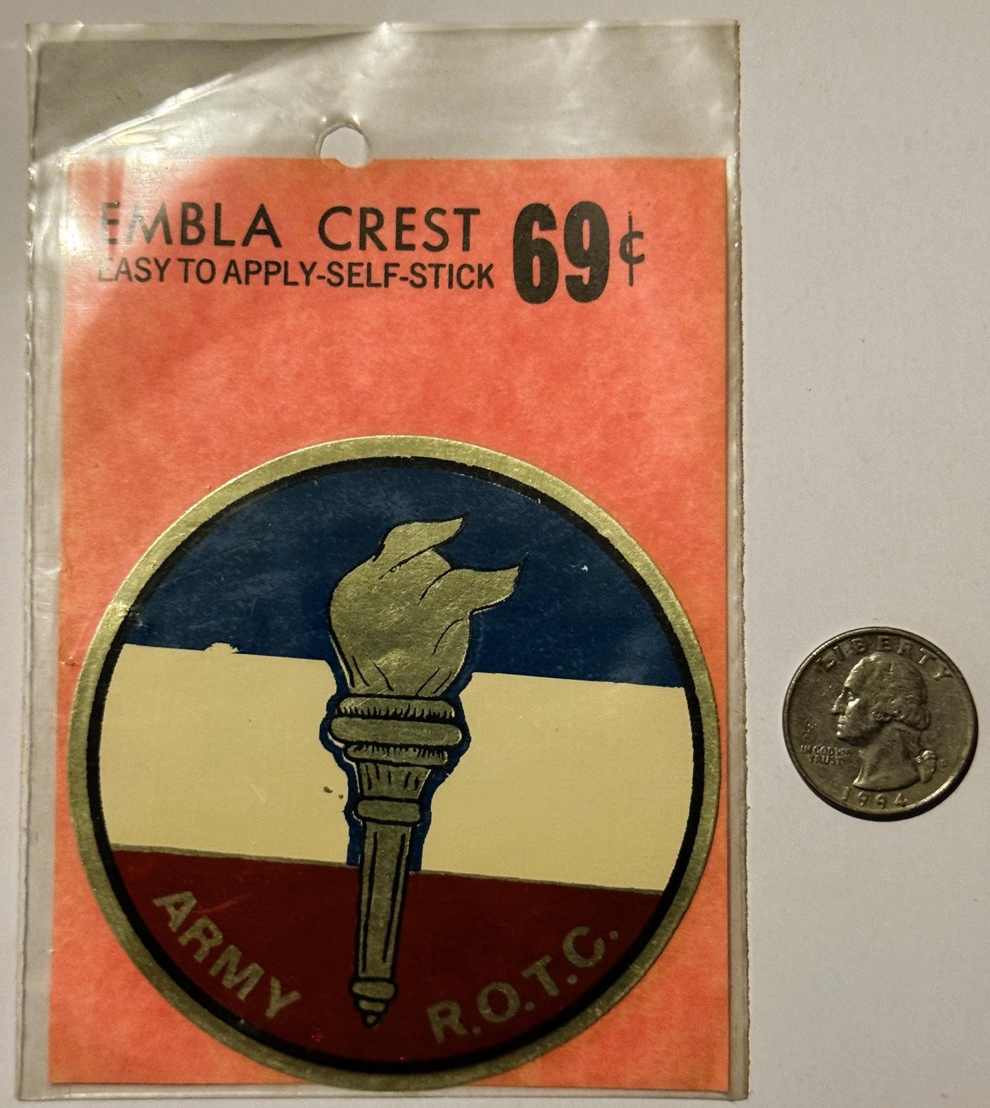 Unopened Army ROTC emblem decal with torch design in red, white, and blue, priced 69¢, shown next to a quarter for scale.