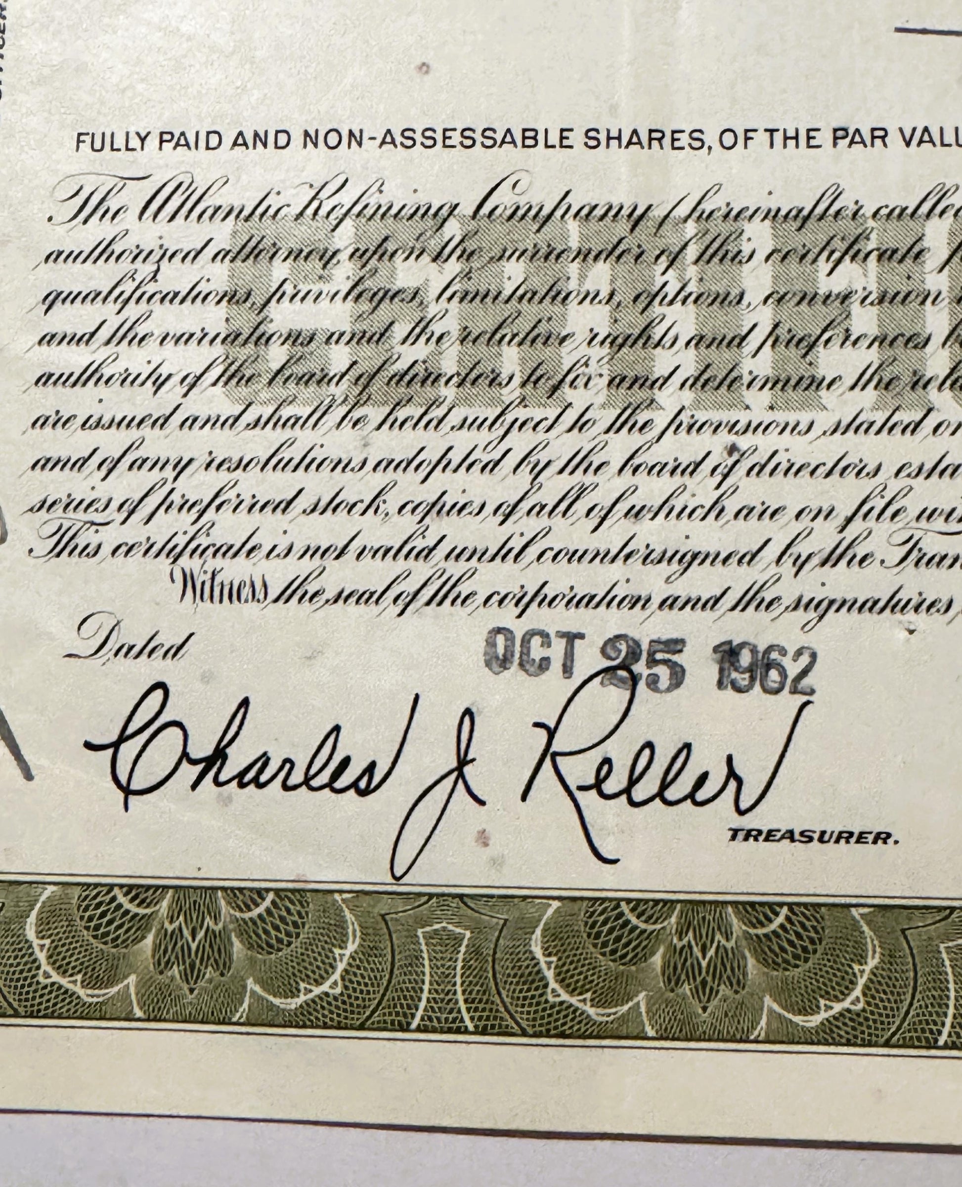 Close-up of stock certificate signature block dated OCT 25, with decorative bor
