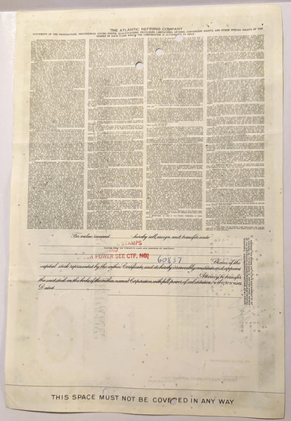 Cream-colored vintage stock certificate from Atlantic Refining Company with dense printed text in four columns and transfer a