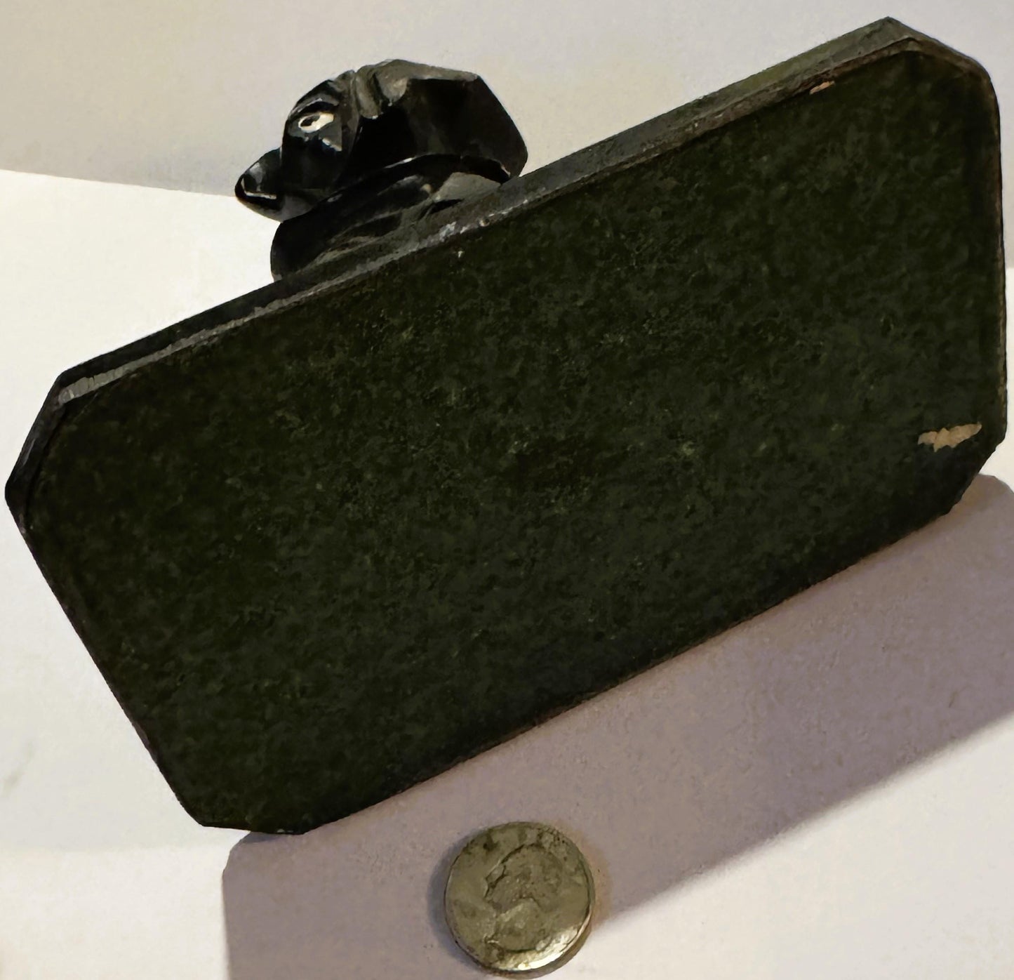 Black cast metal rectangular inkwell base with bulldog figurine on top, shown at angle with US coin for scale