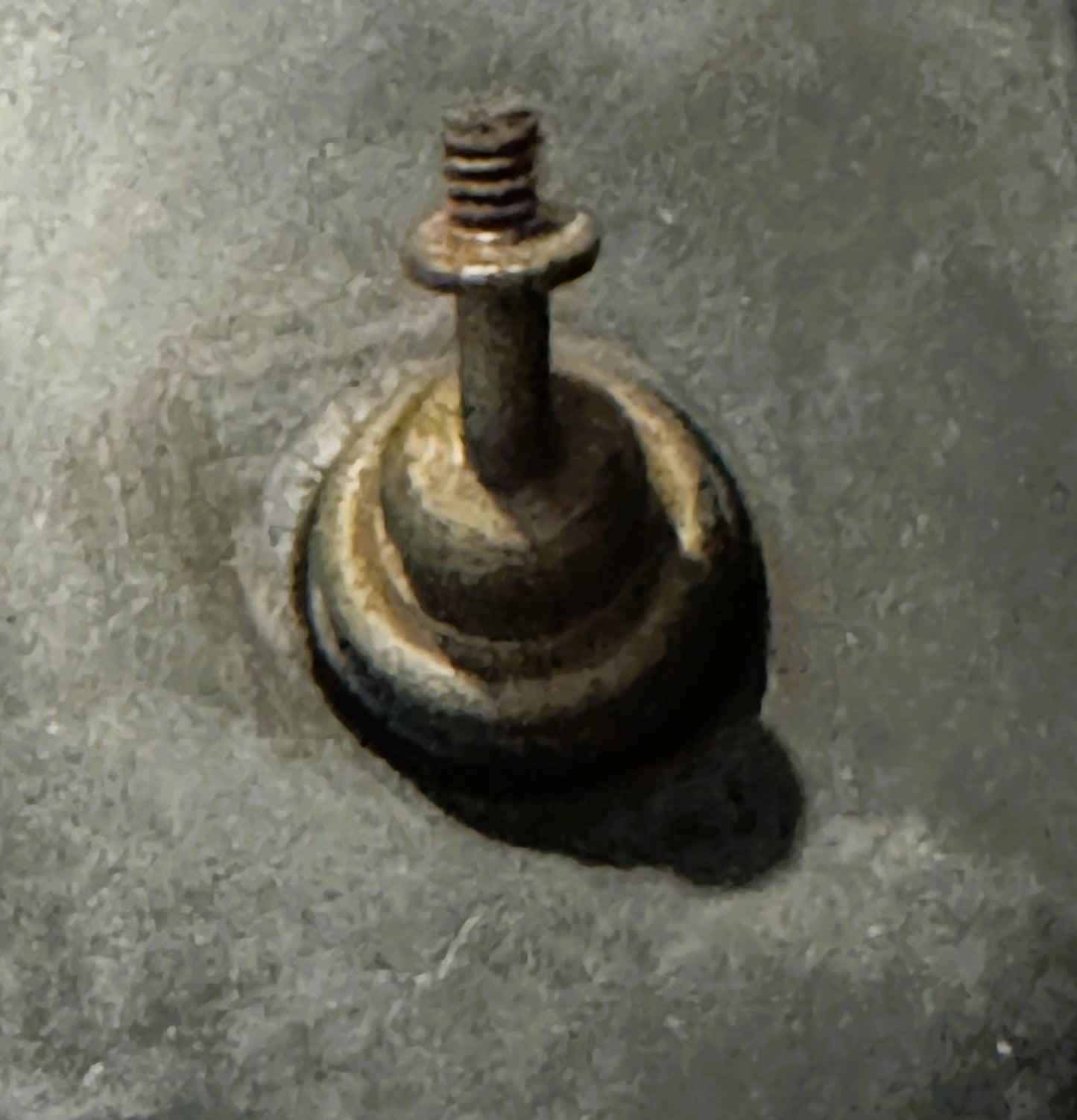 Cast metal inkwell with screw-top lid mounted on rounded bulldog-shaped base, showing patina and wear on concrete surface