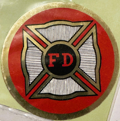 Circular red and gold vintage FD firefighter decal with Maltese cross design and black center circle, mounted on pale green s