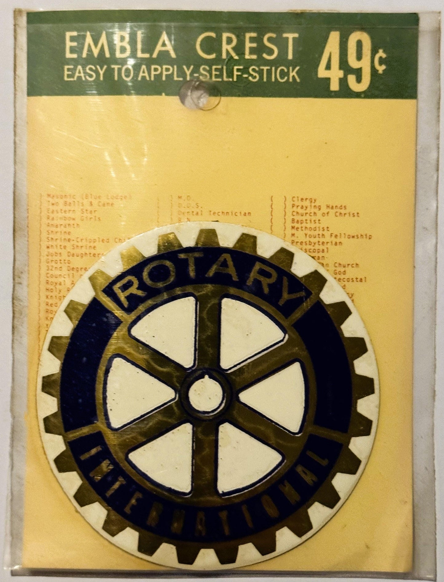 Vintage Rotary International self-stick emblem crest decal priced at 49 cents, featuring a gold gear with white cross design 