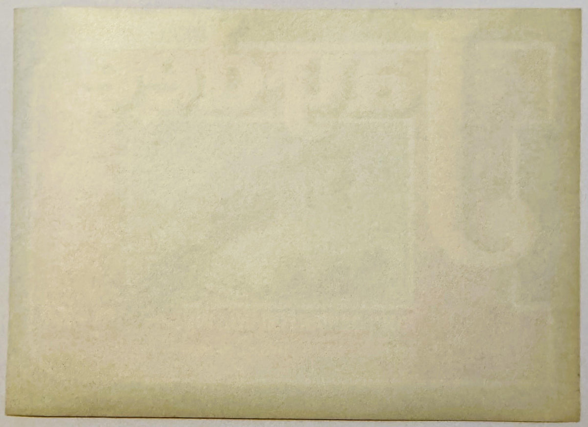 Cream-colored vintage crate label with faded text and subtle printed design, photographed flat against neutral background
