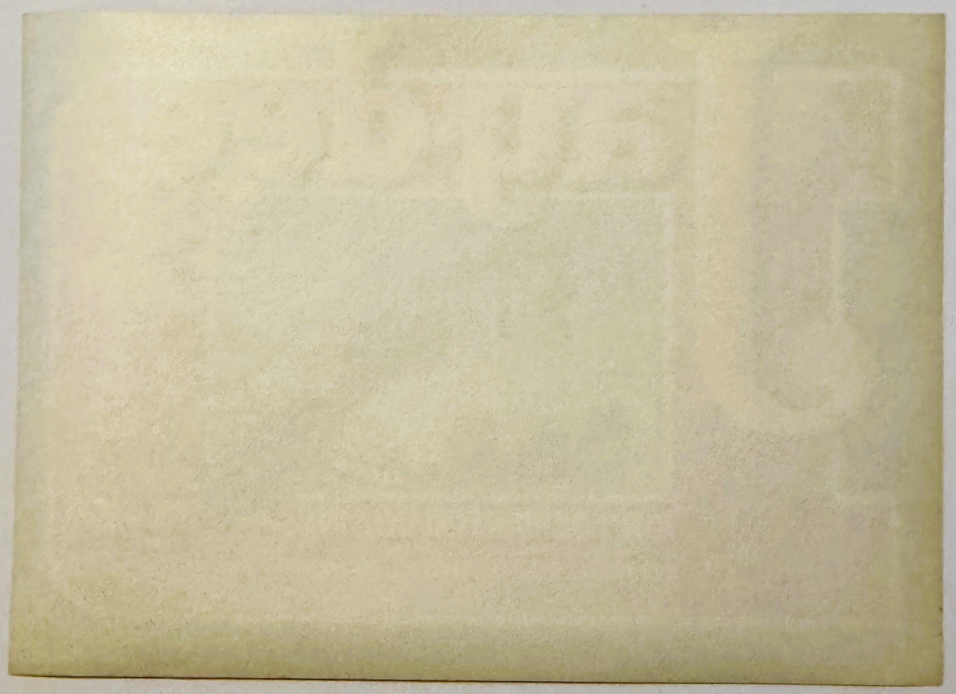 Cream-colored vintage crate label with faded text and subtle printed design, photographed flat against neutral background