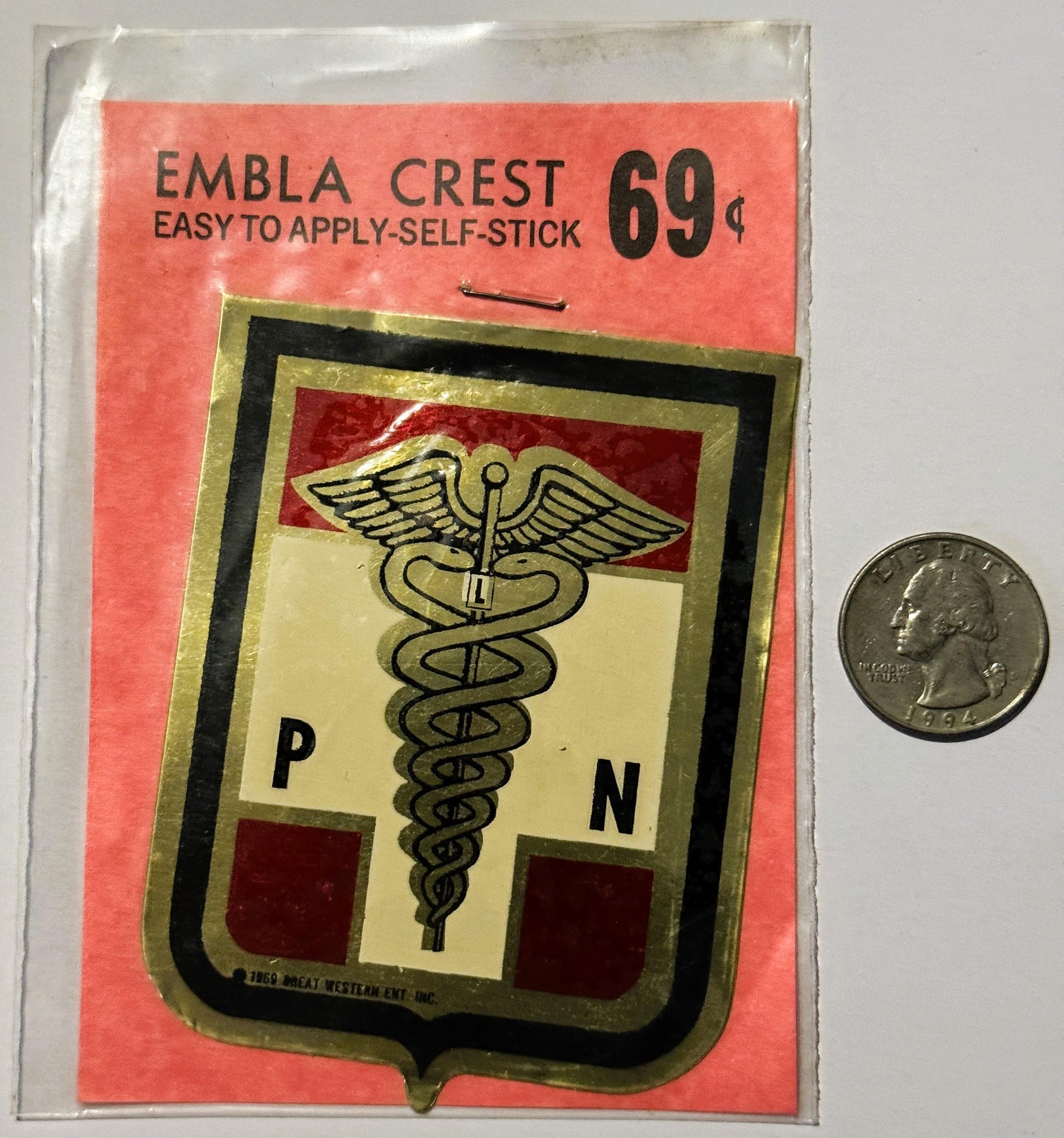 Vintage self-stick emblem crest priced at 69 cents, featuring caduceus medical symbol with P and N letters, displayed next to