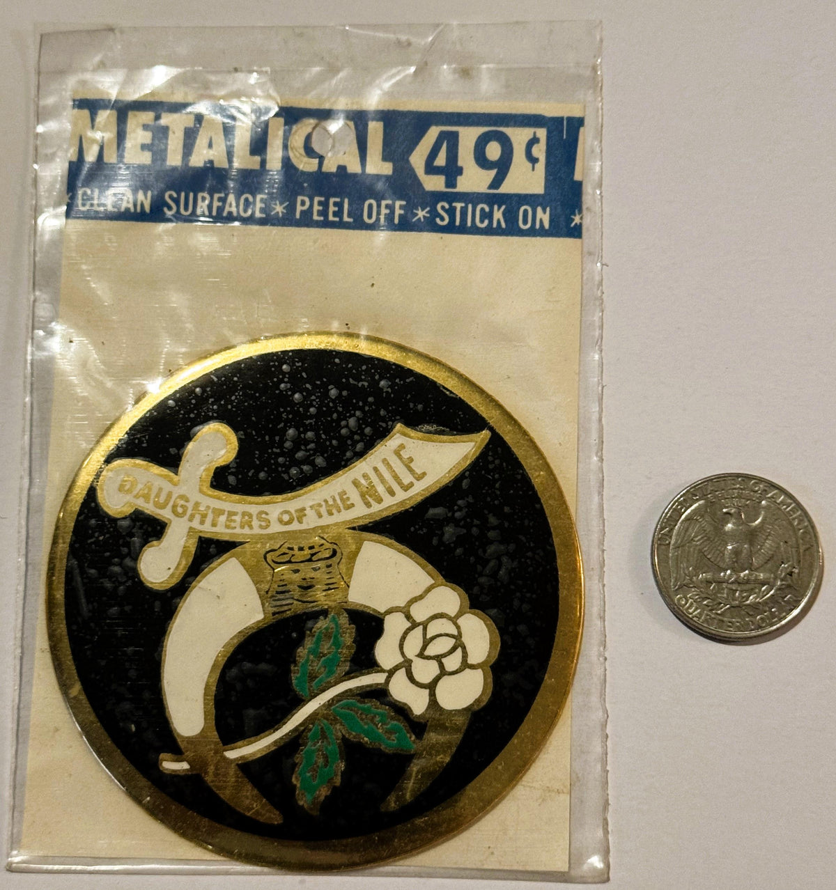 Vintage metallic decal sticker in clear packaging showing "Daughters of the Nile" emblem with sword and flower, priced 49¢, n