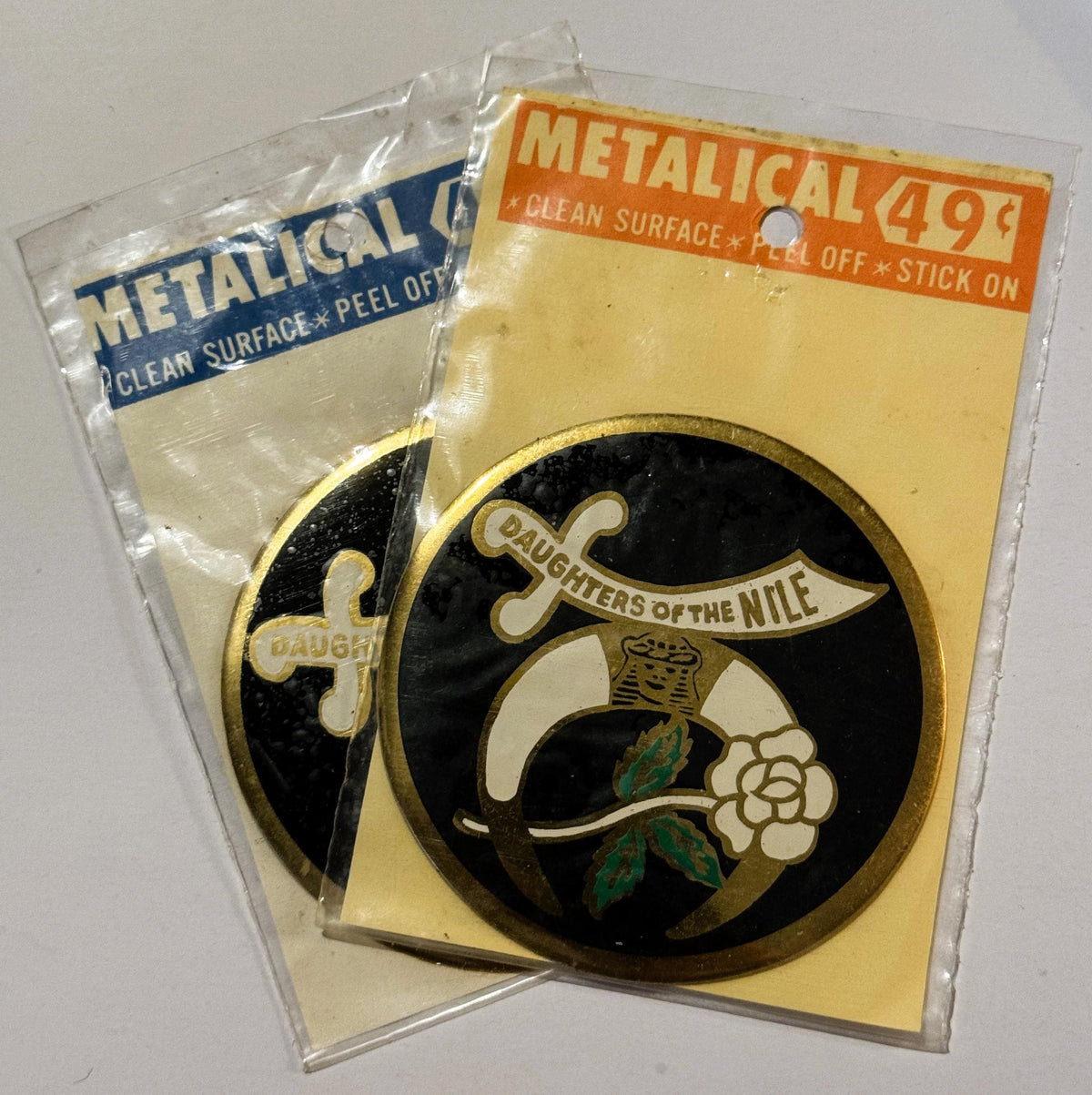 Vintage metallic decal sticker in original packaging showing "Daughters of the Nile" emblem with scimitar and lotus flower on