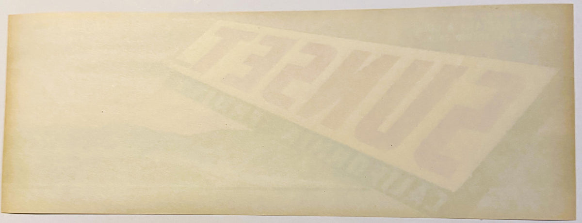 Vintage fruit crate label with faded Sunset brand text and illustration on aged cream-colored paper, photographed flat.