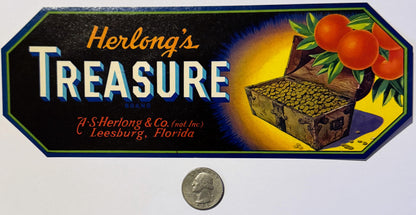 Vintage Herlong's Treasure crate label with pirate chest, oranges, and gold coins, shown with quarter for scale.