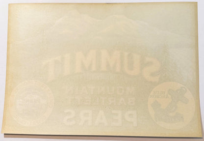 Cream-colored vintage fruit crate label with faint embossed text and circular logos visible at left and right edges, photogra