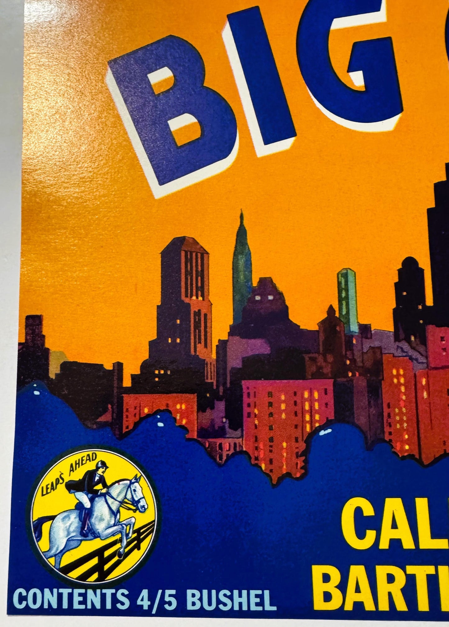 Vintage fruit crate label featuring bold blue and orange design with city skyline, horse rider logo, and "Big City" text at t