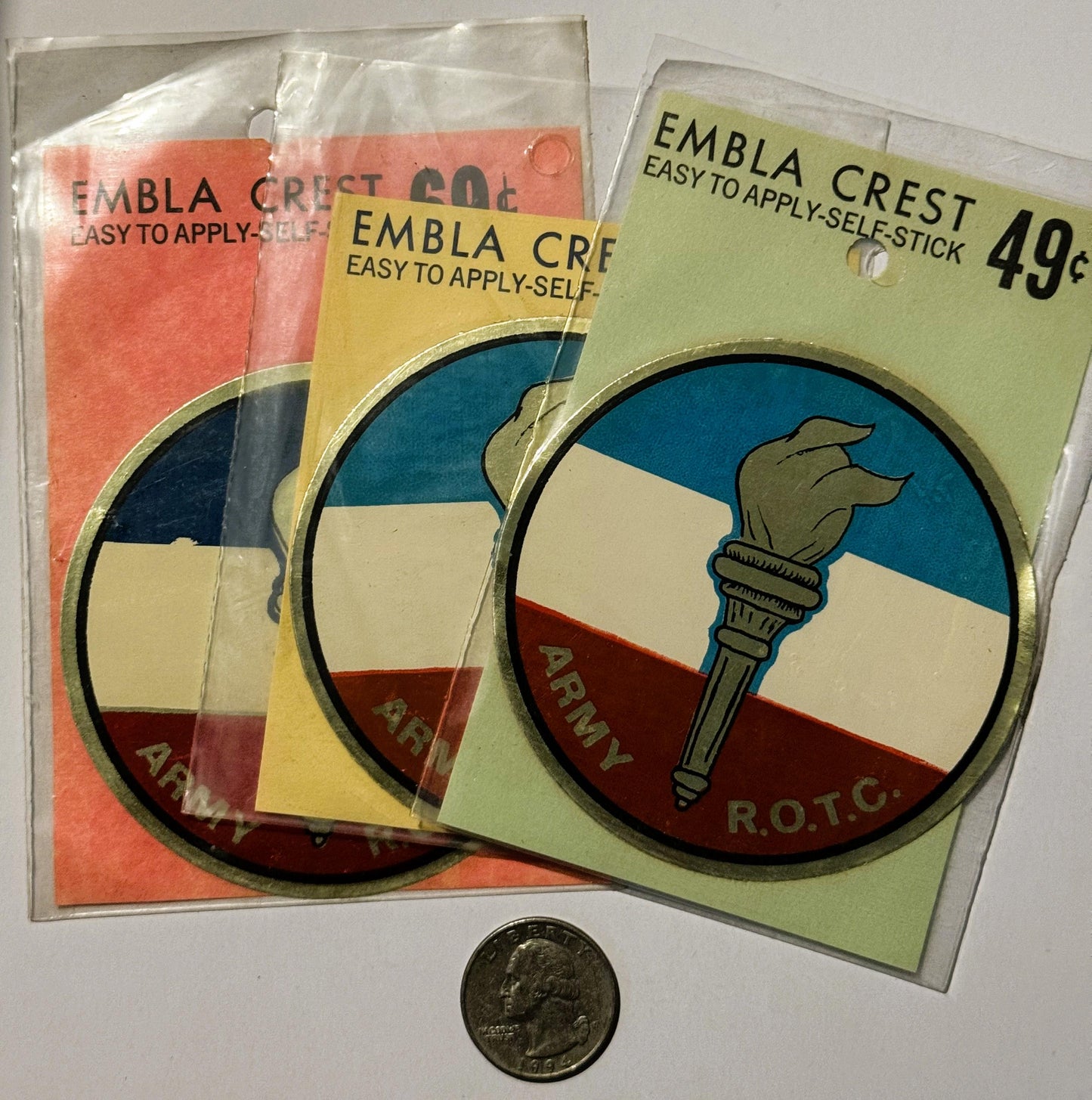 Three vintage Embla Crest self-stick decals in original packaging with Army R.O.T.C. torch emblem, priced at 49¢, shown with 