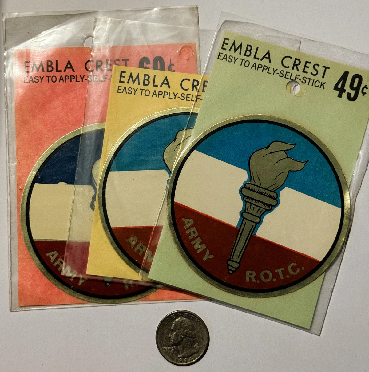 Three vintage Embla Crest self-stick decals in original packaging with Army R.O.T.C. torch emblem, priced at 49¢, shown with 