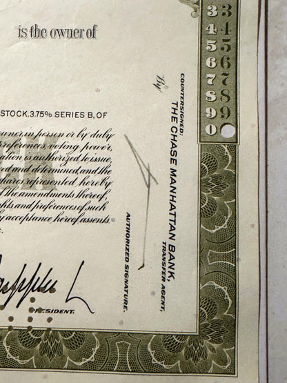 Close-up of vintage stock certificate corner showing ornate green border, numbered scale 3-9, and text reading "is the owner 
