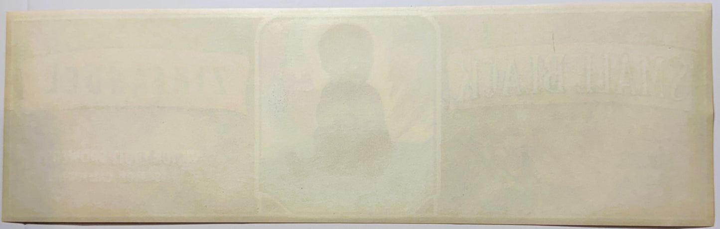 Faded cream-colored vintage fruit crate label with embossed silhouette of person in center, text illegible due to age and fad