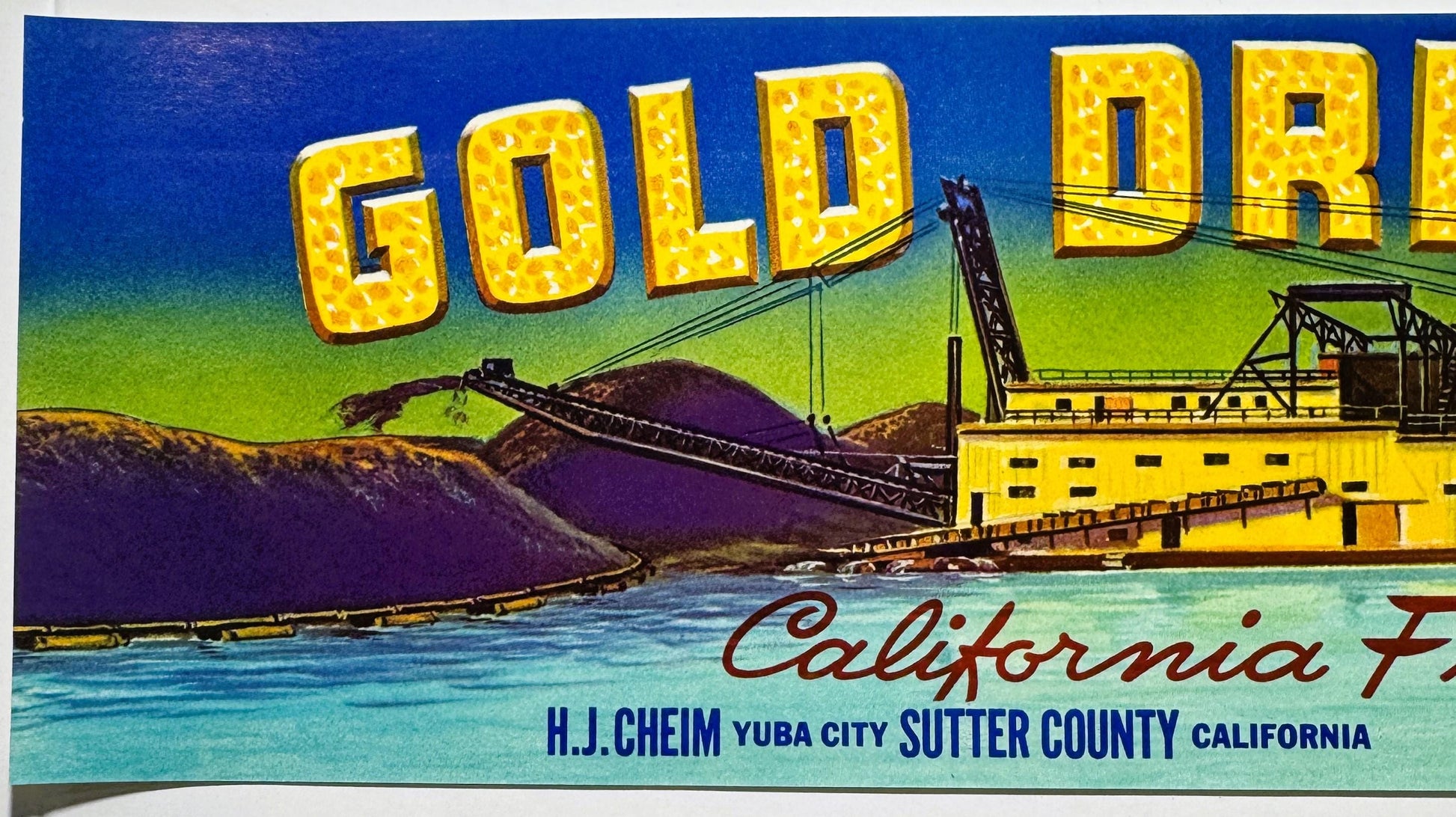 Vintage fruit crate label featuring yellow "GOLD" text, industrial gold dredging equipment, and "H.J. Cheim Yuba City Sutter 