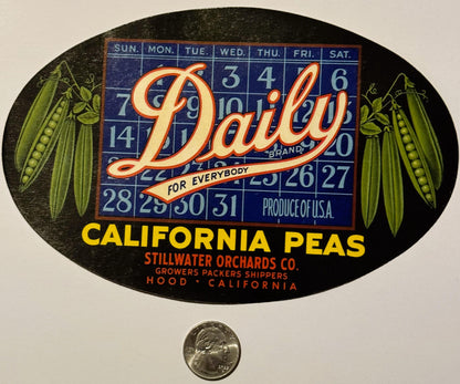 Oval black fruit crate label for Daily Brand California peas with calendar grid, pea pod illustrations, and company details, 