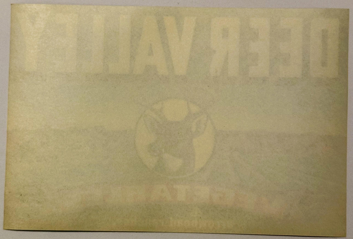 Faded vintage crate label with embossed deer and text, cream-colored paper with age spotting and wear