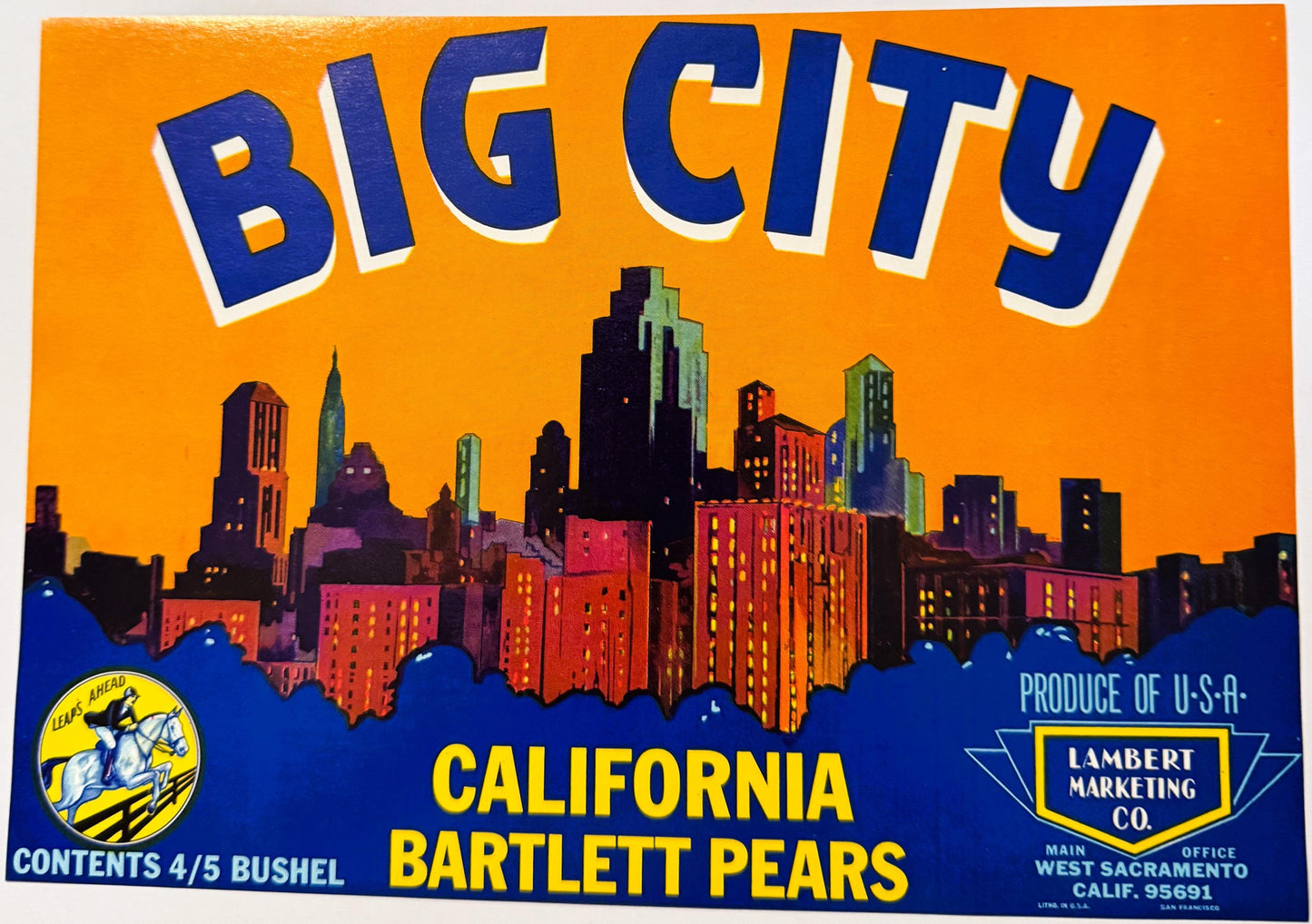 Vintage Big City brand fruit crate label featuring colorful cityscape skyline against orange sky, yellow and blue text, Lambe