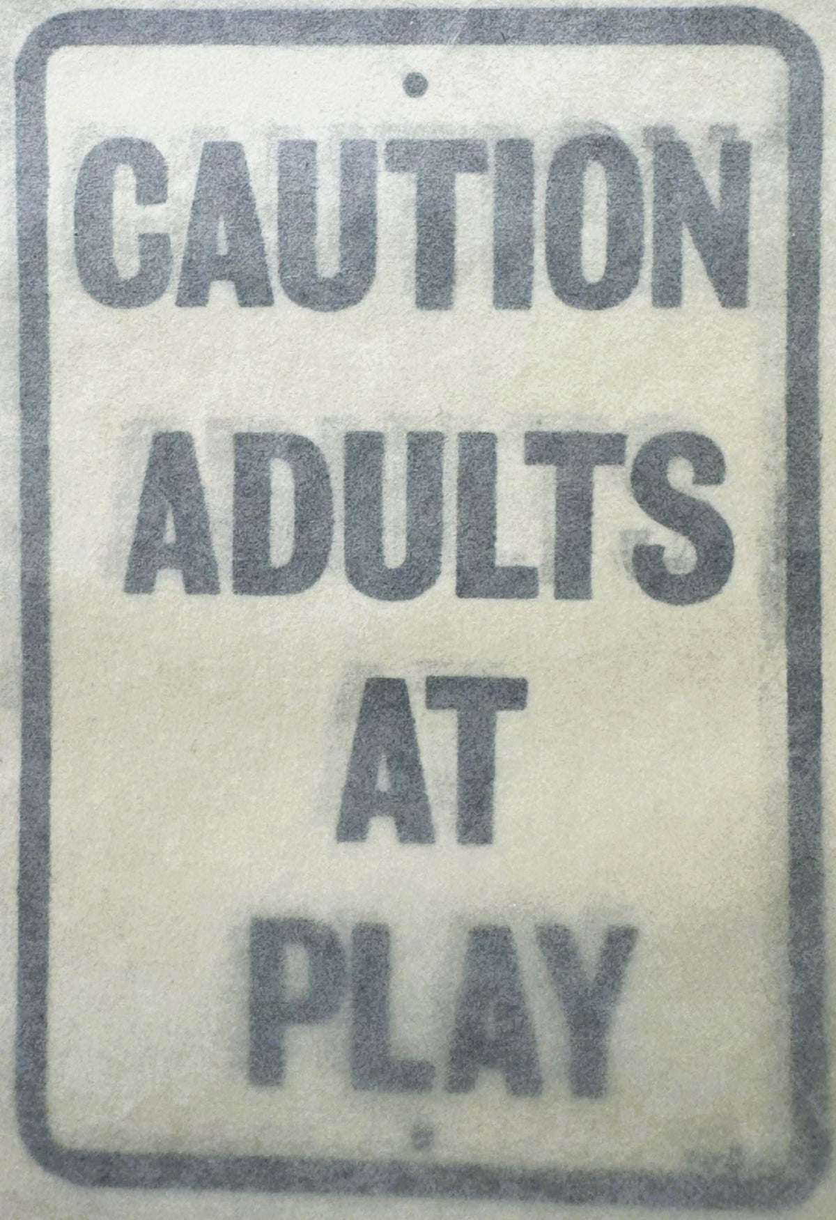 Vintage rectangular decal with gray border and text reading "CAUTION ADULTS AT PLAY" on cream background, photographed flat