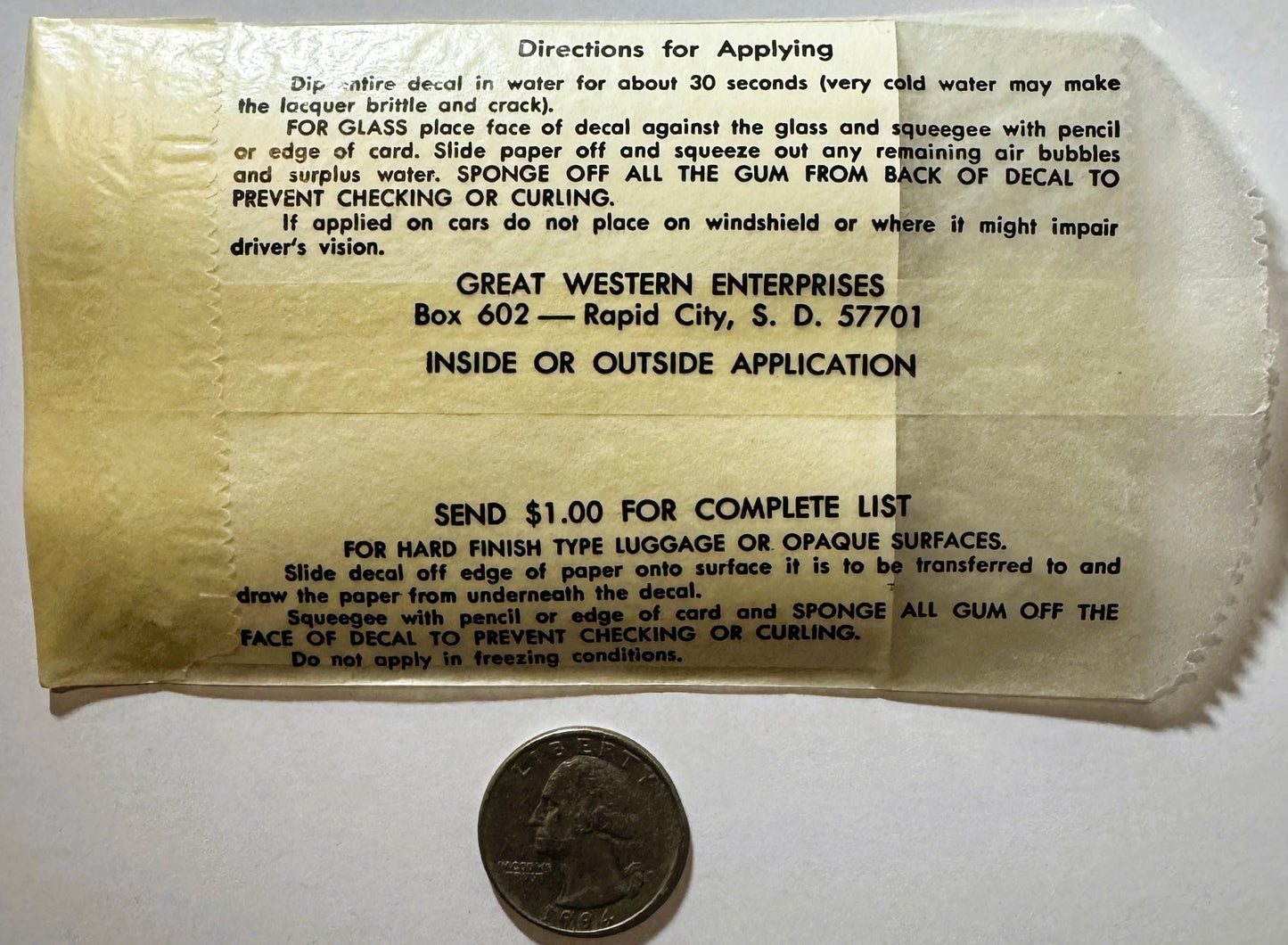 Vintage decal instruction sheet with quarter for scale, yellowed paper showing application directions from Great Western Ente