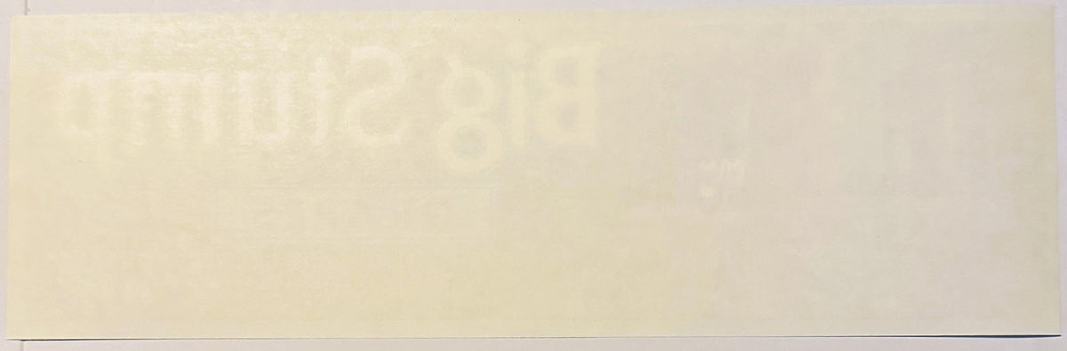 Cream-colored vintage fruit crate label with faint printed design, photographed flat against neutral background
