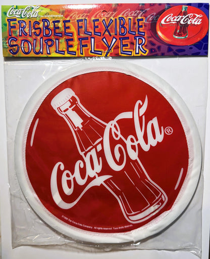Packaged 1999 Coca-Cola red and white flexible flyer disc with bottle logo, shown in clear plastic with colorful header label