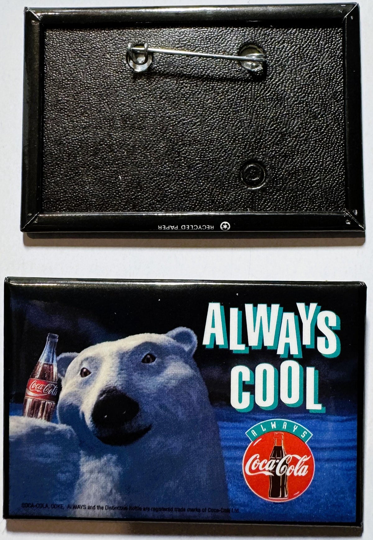 Vintage Coca-Cola pin showing front and back: textured black enamel back with safety pin, colorful front featuring polar bear