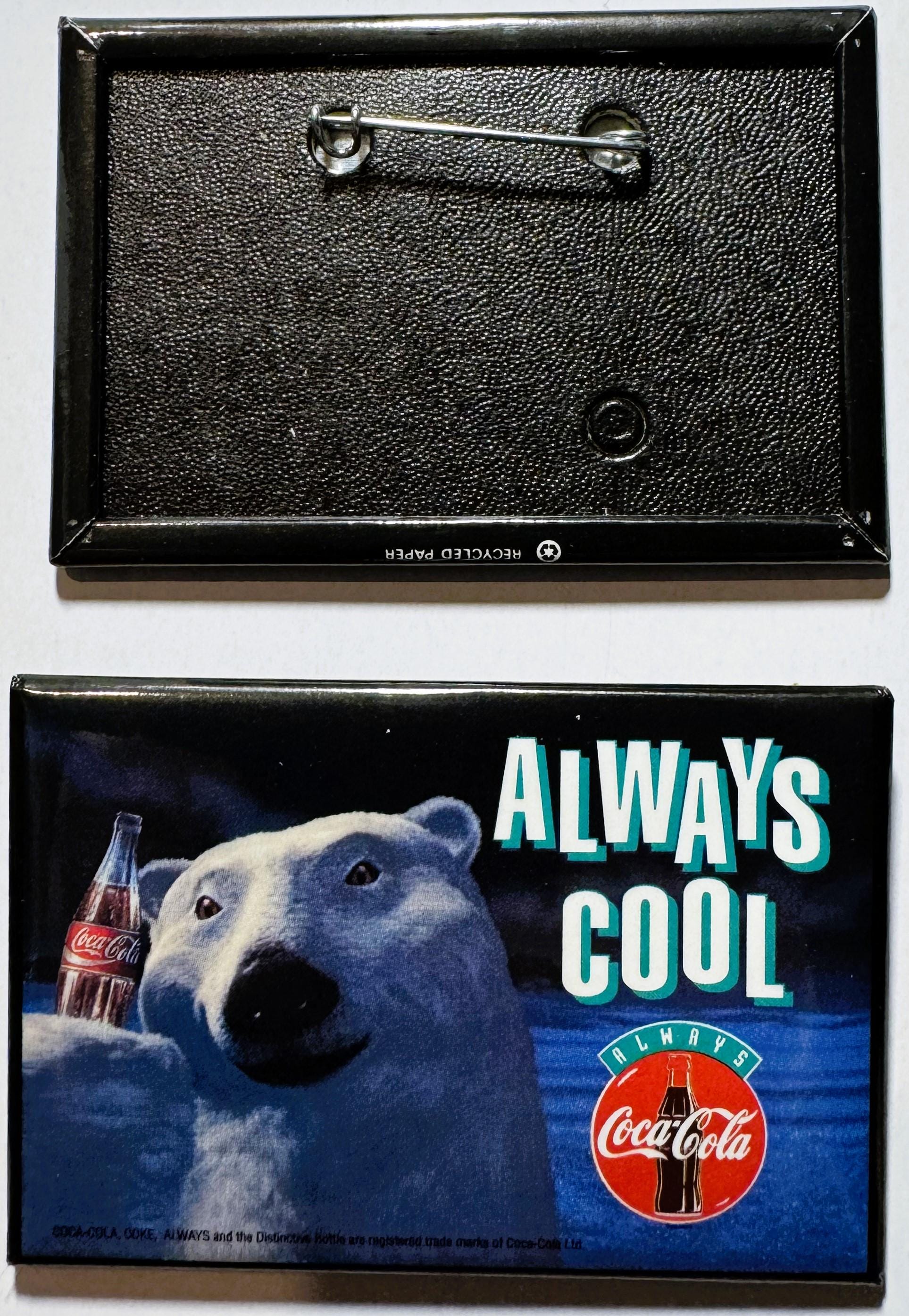 Vintage Coca-Cola pin showing front and back: textured black enamel back with safety pin, colorful front featuring polar bear