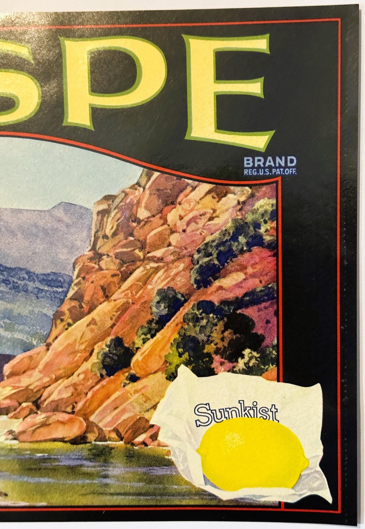 Close-up of the Sespe label's right side: the rocky cliffs and green brush, BRAND REG. U.S. PAT. OFF., and the lemon wrapped in Sunkist tissue