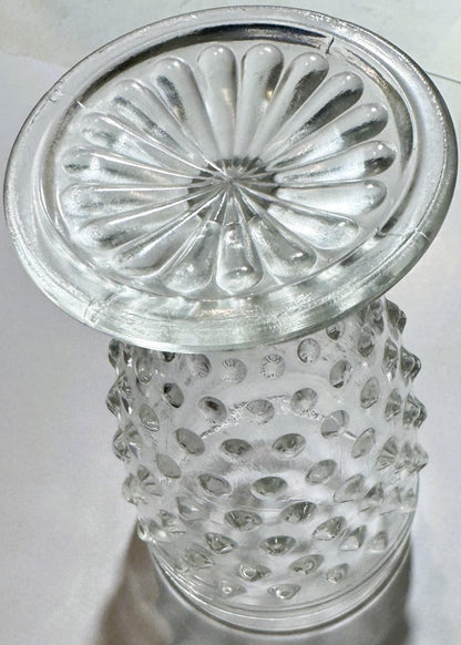 Clear glass hobnail tumbler with scalloped rim viewed from above against white background, showing textured dimpled body and 
