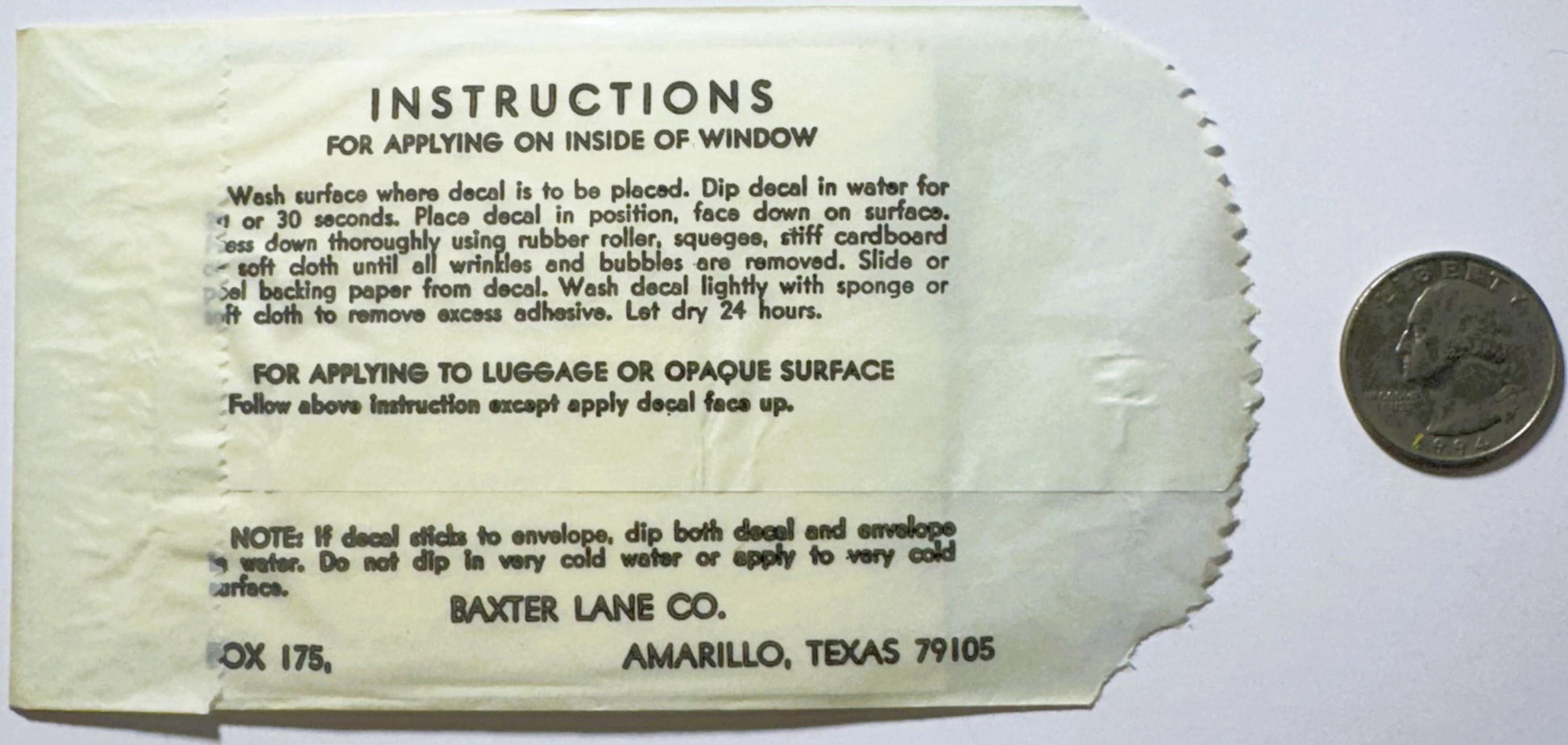 Vintage decal instruction sheet from Baxter Lane Co., Amarillo Texas, with quarter for scale showing wear and yellowing of aged
