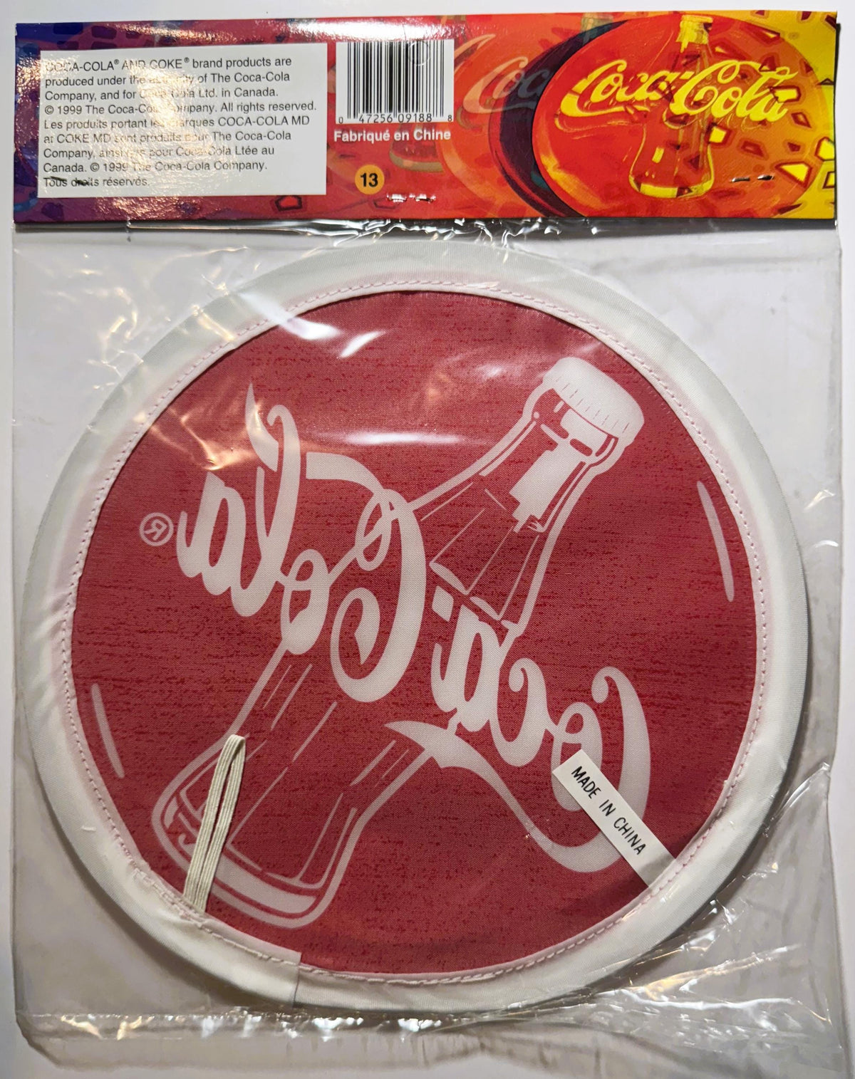 Vintage Coca-Cola red circular promotional disc in clear plastic packaging, showing bottle and script logo, made in China lab