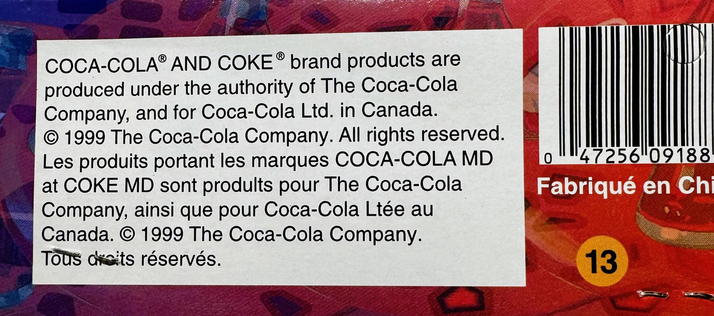 Close-up of copyright and legal text on red Coca-Cola packaging from 1999, with barcode and yellow number 13 visible on right