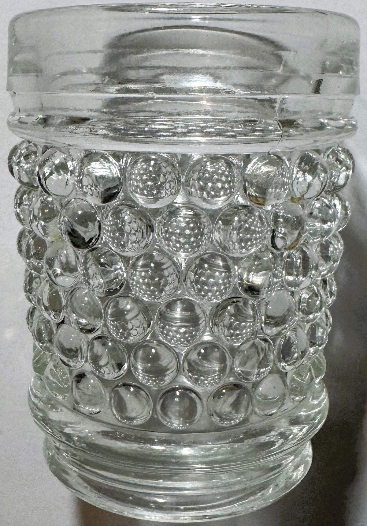 Clear glass hobnail tumbler with bubble texture, shown straight-on against white background, glass lid visible at top.