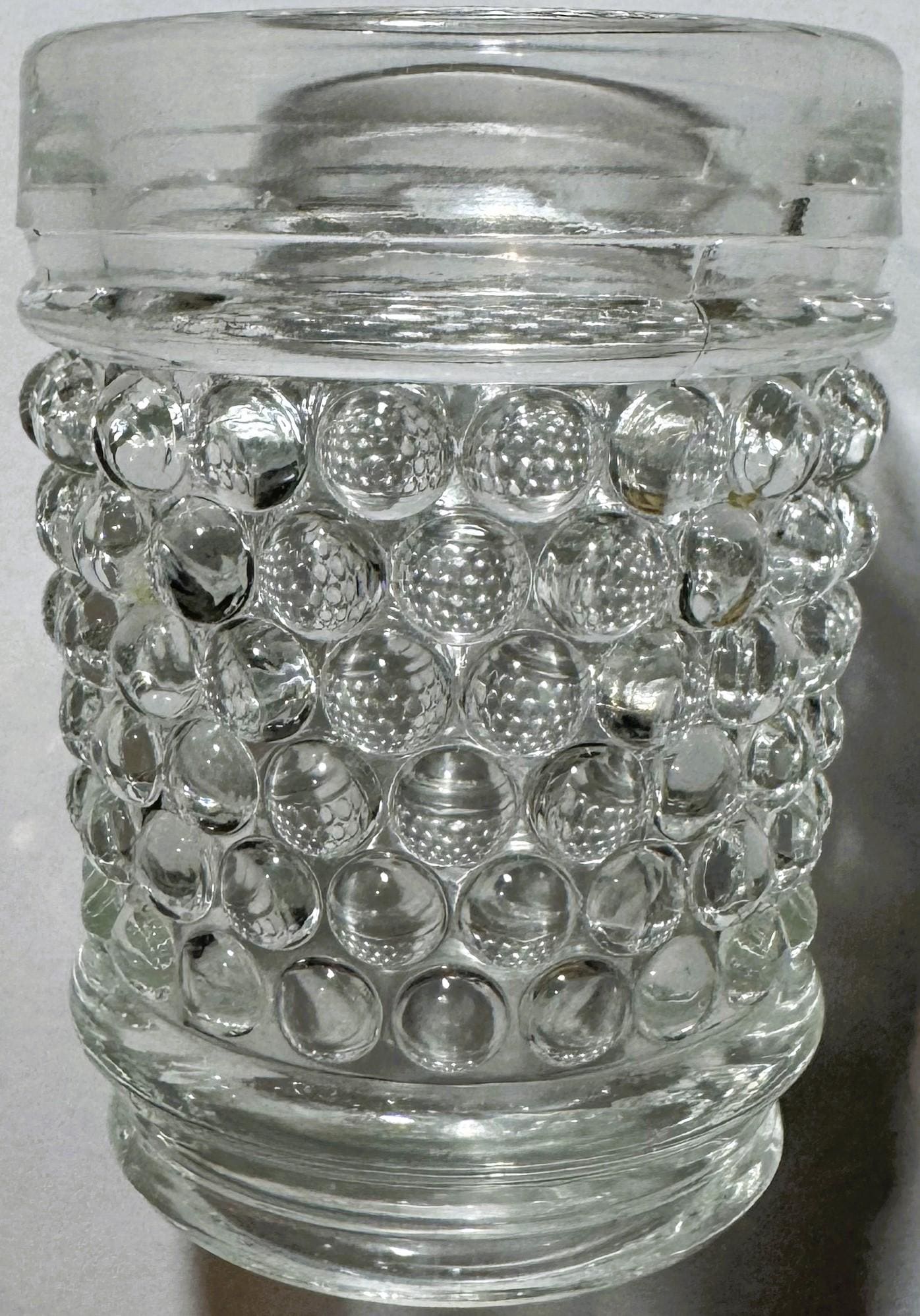 Clear glass hobnail tumbler with bubble texture, shown straight-on against white background, glass lid visible at top.