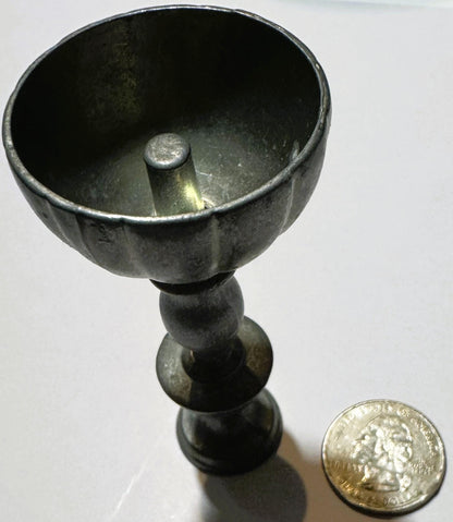 Miniature pewter goblet with fluted bowl and baluster stem next to a quarter for scale, showing patina and maker's stamp on b