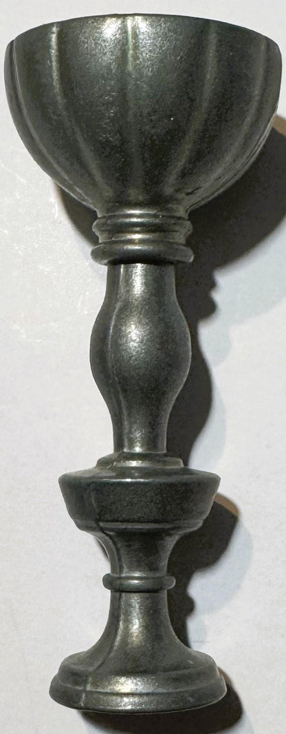 Vintage pewter goblet with fluted bowl and baluster stem, shown against white background with shadow cast to the right