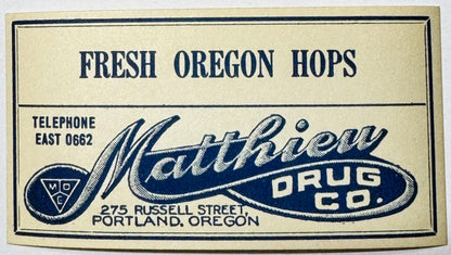 Vintage rectangular drug store label with navy and cream colors, featuring Matthew Drug Co. branding and hop imagery, Portlan