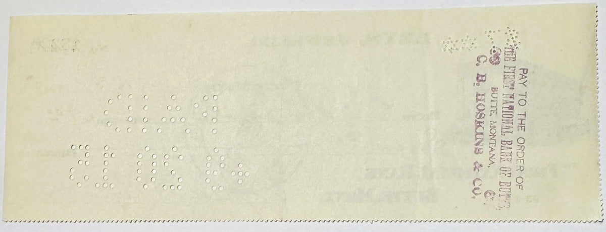 Back of vintage bank check from Butte, Montana jeweler with embossed circles forming numbers, postage stamp visible in upper 